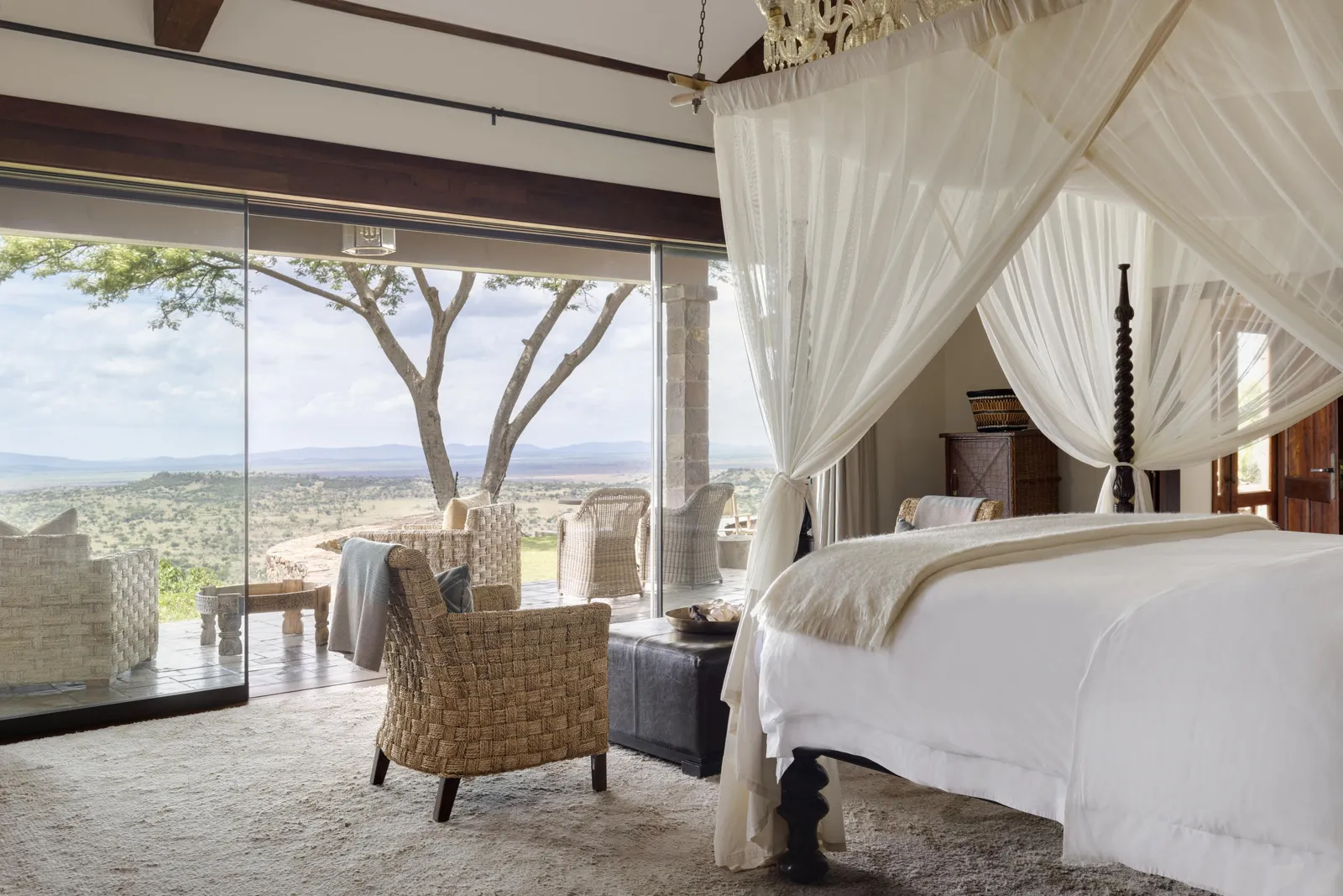 Canopy bed and valley view from a suite at Singita Sasakwa in the Serengeti